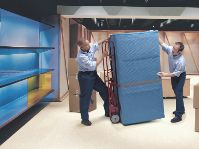 Two men with a dolly moving boxes